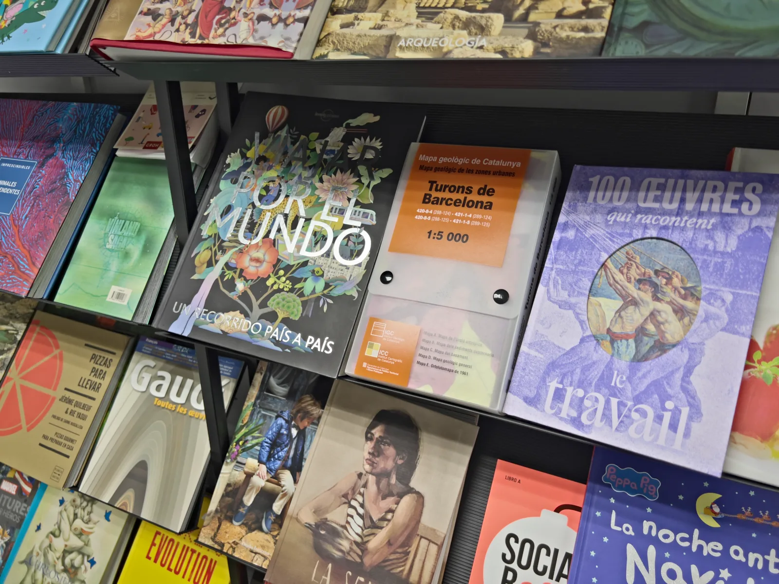 Expositor amb revistes, llibres i un mapa geològic plegat